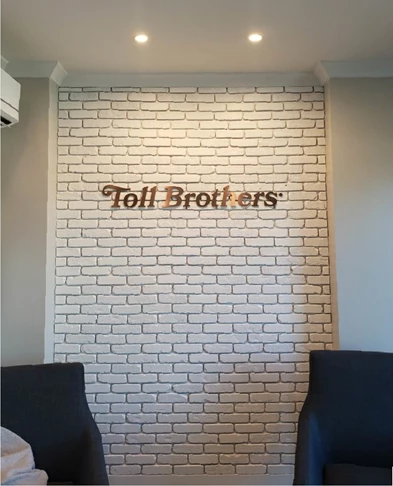 Toll Brothers logo in a beautiful oil rubbed bronze dimensional lettering, mounted on brick.